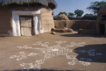 Village hut decorated for the Camel Festival with white painted motifs on the ground outside Asia Asian Nepalese Bharat Inde Indian Intiya Male Men Guy Male Man Guy Religion Religious