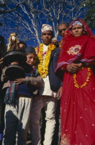 Bride and groom during wedding procession. Groom wearing a marigold garland and bride dressed in red. Asia Asian Nepalese Kids Marriage Religion Religious