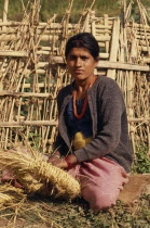 Portrait of woman with a nose piercing sat on the ground weaving in Mayam VillageAsia Asian Nepalese Female Women Girl Lady Female Woman Girl Lady One individual Solo Lone Solitary