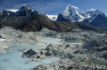 Trekkers crossing an ice lake on the Ngozumpa Glacier with mountains Cholatse on the left and Tawachee on the right in the background.Asia Asian Nepalese Scenic