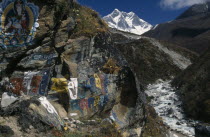 Buddhist wall paintings beside the trail between Pangboche and Shomare with snow capped Lhotse mountain in the backgoundAsia Asian Nepalese Religion Religious Buddhism Buddhists Scenic