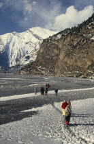 Circuit Trek. Thakali villagers walking on the snow covered trail between Tukuche and Khobang Asia Asian Nepalese Scenic