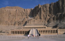 Deir el-Bahri. Hatshepsut Mortuary Temple. Visitors walking towards ramped entrance with limestone cliffs behind.African Middle East North Africa History Religion Religious