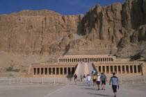 Deir el-Bahri. Hatshepsut Mortuary Temple. Visitors walking towards ramped entrance with limestone cliffs behindAfrican Middle East North Africa History Religion Religious