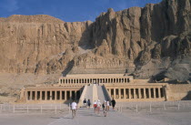 Deir el-Bahri. Hatshepsut Mortuary Temple. Visitors walking towards ramped entrance with limestone cliffs behindAfrican Middle East North Africa History Religion Religious