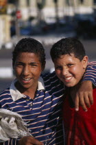 Portrait of two boys smiling with one boys arm over others shoulderAfrican Middle East North Africa Happy Kids Contented 1 2 Single unitary