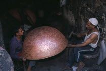 Coppersmith working on a large bowl in the Khan el-Khalil area of  famous narrow streets of bazaars.African Middle East North Africa