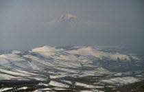 Aerial view over peaks of Mount Ararat from Voghaberd with Yerevan on the right  note air pollution.  Twin peaked mountain resulting from volcanic activity.Armenian Asia Ecology Entorno Environmental...