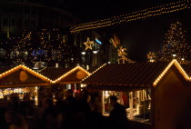 Breitscheidplatz. Christmas Market. People gathered around Illuminated stalls at night with lights and star decorations aboveDeutschland European Nite Religious Western Europe Xmas Religion