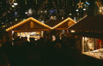 Breitscheidplatz. Christmas Market. People gathered around Illuminated stalls at night. Lights and star decorations behindDeutschland European Nite Religious Western Europe Xmas Religion
