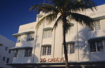 South Beach. Ocean Drive. The Carlyle Hotel seen in early morning light with a palm tree casting a shadow on the exterior American North America United States of America Beaches Resort Sand Sandy Sea...