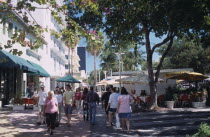 South Beach. Lincoln Avenue. People walking under trees on pedestrian promenade lined with shops and street cafes near The Lincoln Theatre American North America United States of America Beaches Reso...