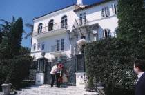 South Beach. Ocean Drive. Gianni Versace s Mansion Casa Casuarina.  Man and woman peering through the gate at main entranceAmerican North America United States of America Beaches Resort Sand Sandy Se...