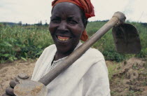 Portrait of woman with hoe  a member of the Women s Agricultural Association reformed after the genocide.