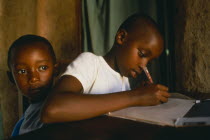 Children of Tutsi returnee family doing homework.  The family fled to Uganda over thirty years ago  but have returned under the new regime.