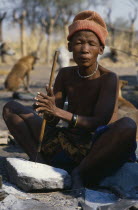 Bushwoman making beads from ostrich egg shell.