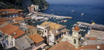Sorrento.  View over red tiled roof tops and church bell tower towards Marina Grande and moored boats.Italia Italian Southern Europe European