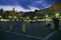 Piazza del Campo.  Night view over Il Campo and cafes with people walking or sitting on the red brick paving.Italia Italian Nite Southern Europe European Toscana Tuscan