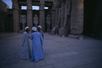 Group of three men talking inside the temple of Luxor Statues in background African History Male Man Guy Middle East North Africa Male Men Guy 3