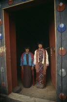Two girls framed by doorway of monastery.