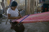 Woman weaving textile on hand loom at Los Liros Guatemalan refugee camp.