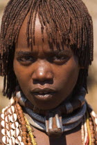 Hamer Jumping of the Bulls initiation ceremony  Married Hamer lady  her hair greased with ocher colouring and animal fat into plaits known as Goscha. She is wearing a necklace know as a Bignere - an m...