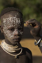 Karo woman painting her daughters face
