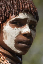 Woman with face painting  her hair greased with ocher colouring and animal fat into plaits known as Goscha