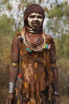 Woman with face painting  her hair greased with ocher colouring and animal fat into plaits known as Goscha and traditional goatskin dress decorated with cowrie shells