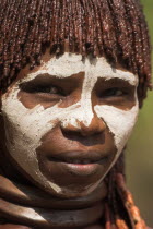 Banna woman  her hair greased with ocher colouring and animal fat into plaits known as Goscha