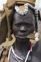 Portrait of woman with feather in her mouth.