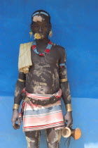 Tsemay man in traditional attire with flower in mouth at weekly market