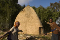 Traditional beehive house of the Dorze peoples which are made entirely from organic materials and can last up to 60years  Women carrying bamboo
