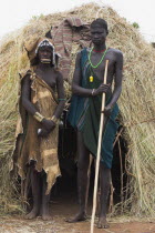 Couple standing outside their hut