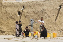 Children fill up water containers at well near houses inside ancient walls of Citadel  The citadel was destroyed during First Anglo Afghan war since rebuilt still used as a military garrison