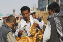 Men buying bread from street stall