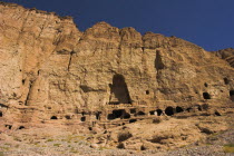 Caves in cliffs near empty niche where the famous carved small Budda once stood 180 foot high before being destroyed by the Taliban in 2001