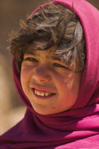 Girl that lives in a cave in the cliffs near empty niche where the famous carved small Budda once stood 180 foot high before being destroyed by the Taliban in 2001