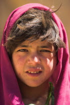 Girl that lives in a cave in the cliffs near empty niche where the famous carved small Budda once stood 180 foot high before being destroyed by the Taliban in 2001