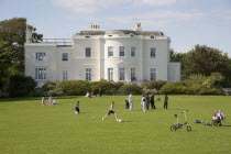View of the rear of Beach House  seen from the grounds with families and children playing football on the grass