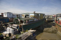 Houseboat moored along the banks of the river adur.  Former barges converted into homes with the use of various bits of junk  including cars  buses and washing machines.