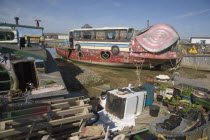 Houseboat moored along the banks of the river adur.  Former barges converted into homes with the use of various bits of junk  including cars  buses and washing machines.