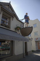 Exterior of the Crown and Anchor public house in the high street with ships mast head figure in the fonrt of the building.