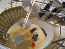 The De La Warr Pavilion. Interior view down the helix staircase with chrome Bauhaus globe lamps. Visitors walking the stairs and people sitting on chairs seen at the bottomDesigned by Erich Mendelsoh...