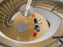 The De La Warr Pavilion. Interior view down the helix staircase with chrome Bauhaus globe lamps. People sitting on colourful chairs at the bottomEuropean Great Britain Northern Europe UK United Kingd...