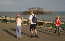Woman jogging with man rollerblading on the seafront promenade.European Great Britain Northern Europe UK United Kingdom British Isles