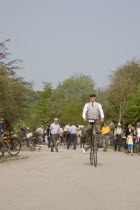 Amberley Working Museum. Veteran Cycle Day Grand Parade. Man wearing period custom riding a Penny Farthing bicycle with visitors watching.