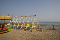 Colourful children s amusement rides on shingle beach