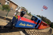 Families enjoying the Miniature Railway train ride at Norfolk Gardens. Union Jack Flag flying behind