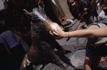 Mercato Nuovo. Fontana del Porcellino. Bronze fountain of a boar with a woman rubbing the snout for good luck